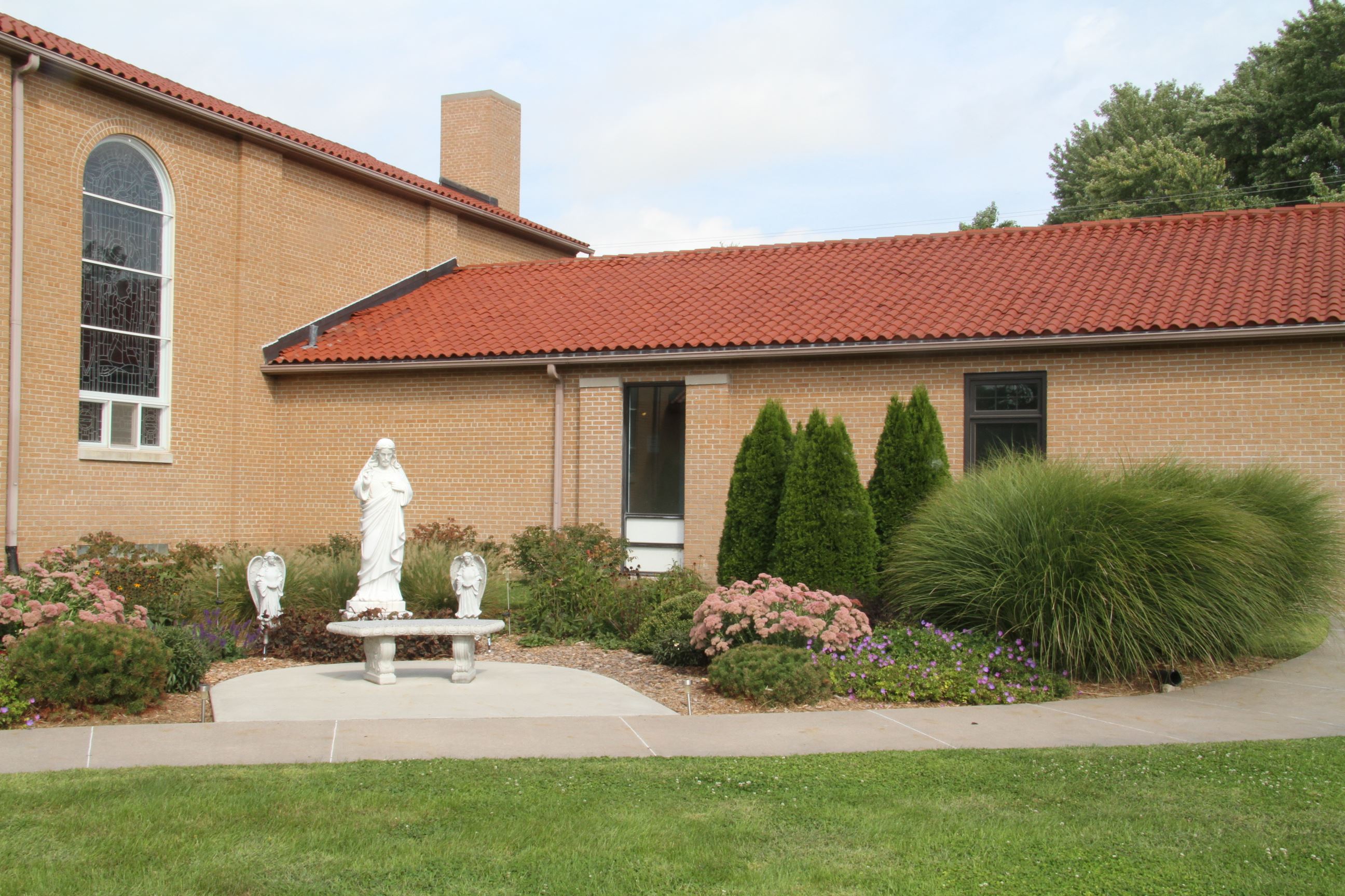 Sacred Heart Church Building with Sculpture on Grounds