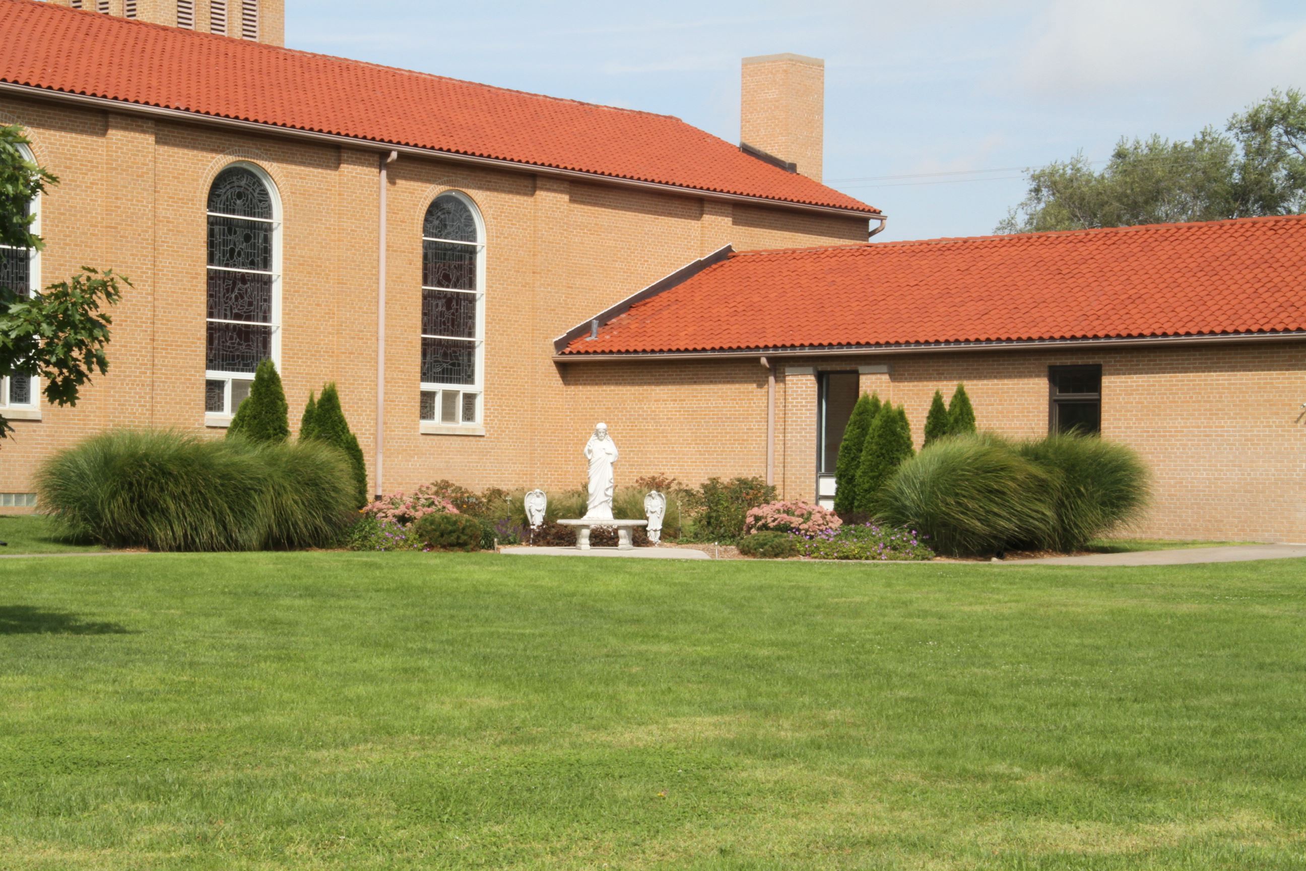 Sacred Heart Church Building with Sculpture on Grounds